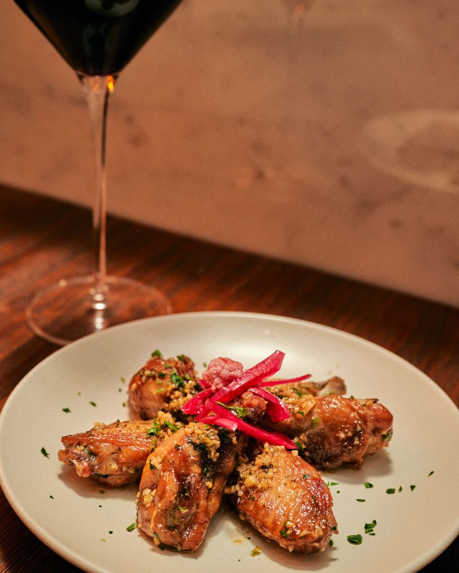 Ailes de poulet à l'ail et au persil, verre de vin rouge
